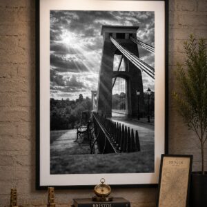 Framed black and white Clifton Suspension Bridge wall art print featuring dramatic sun rays and the iconic bridge tower.